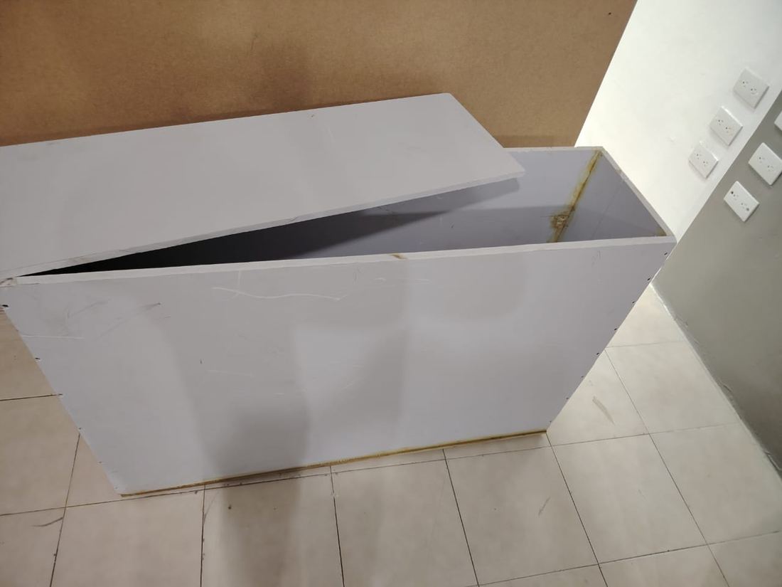 Caja de MDF blanca con la tapa apoyada, recién armada